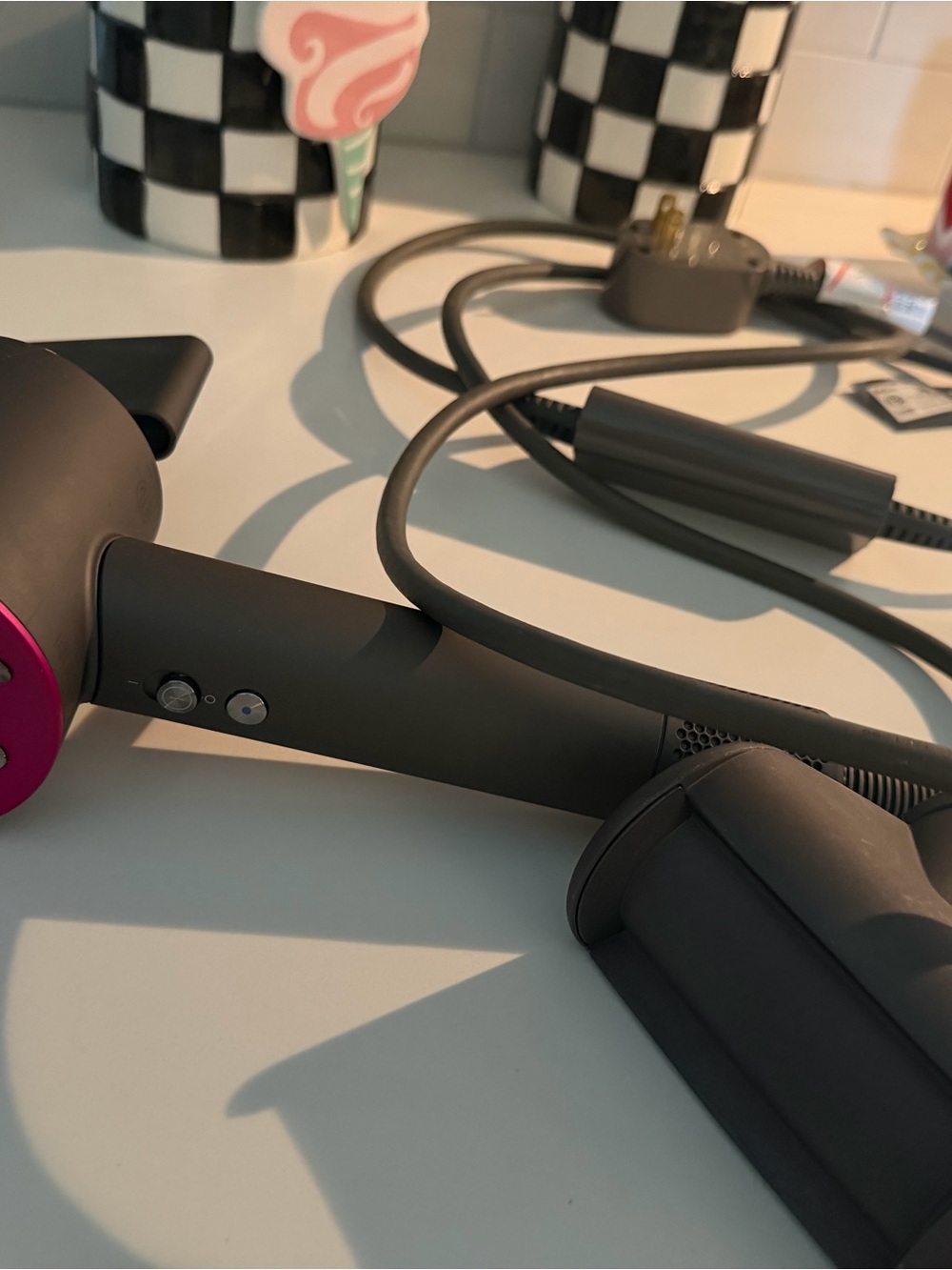 Dyson hair dryer in matte black with magenta accents